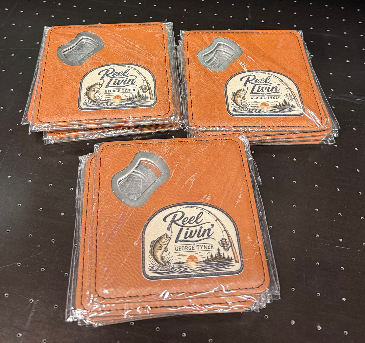 Packaged bottle-opener coasters with a UV-printed Reel Livin design and George Tyner personalization.