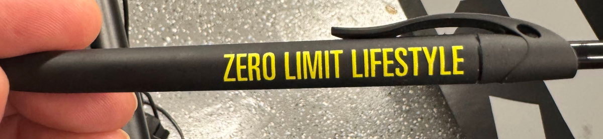 Black pen with yellow Zero Limit Lifestyle printed branding, close-up.